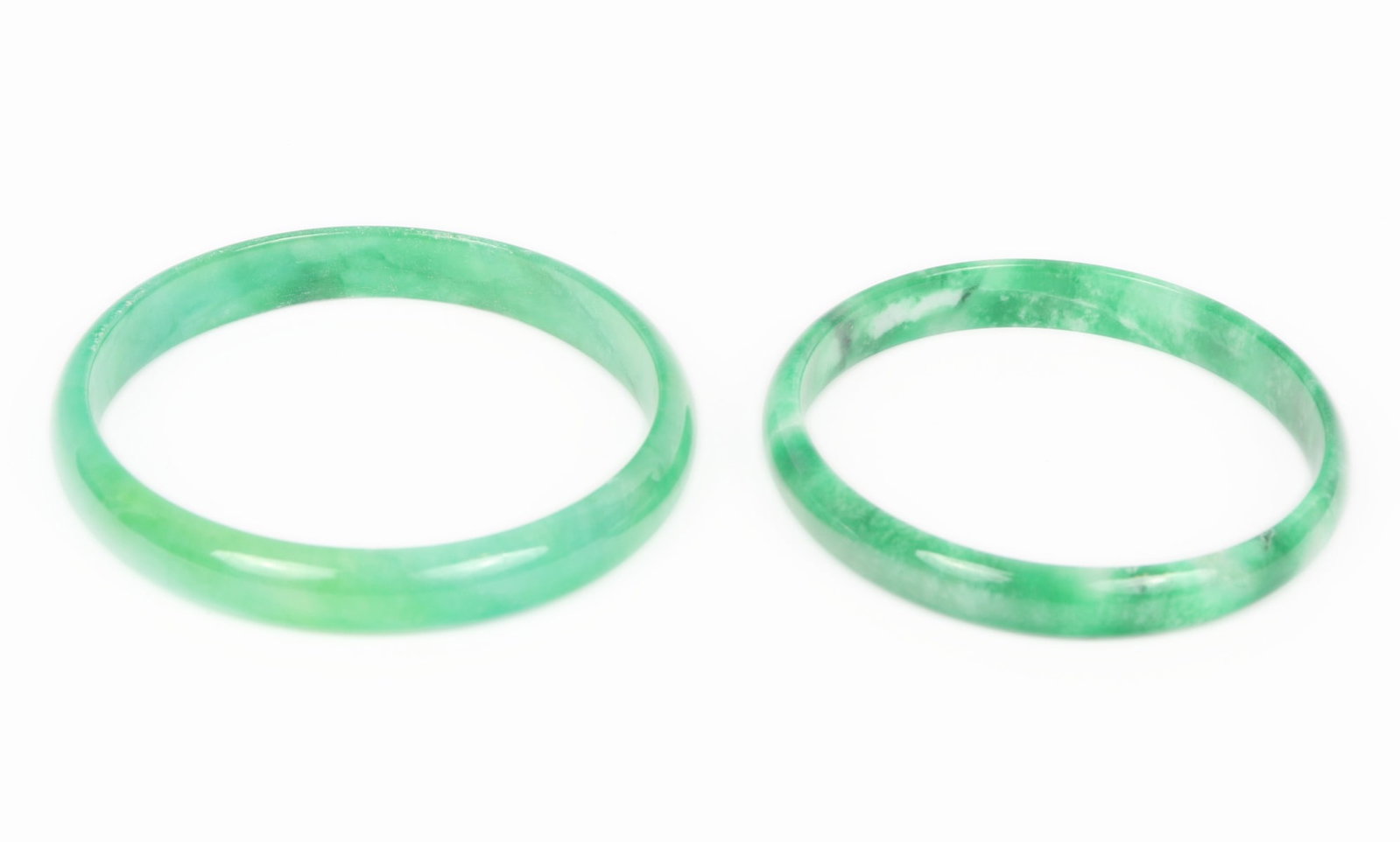 Beautiful Pair of Chinese Jade Style Bangle Bracelets: Gorgeous pair of light green marbled Chinese jade style bangle bracelets. Each with lovely white cloud like clusters throughout, polished smooth and cool to the touch. Size of each opening