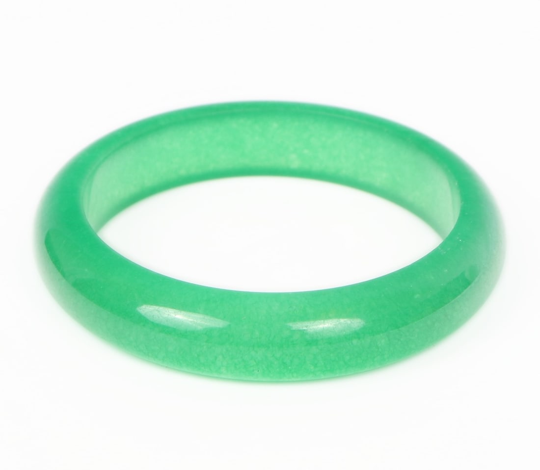 Lovely Chinese Green Bangle Bracelet: Beautiful Chinese jade style bangle bracelet in a gorgeous bright green color. Cold to the touch and polished smooth throughout, the piece has areas of translucency when held to natural light. Size 2 