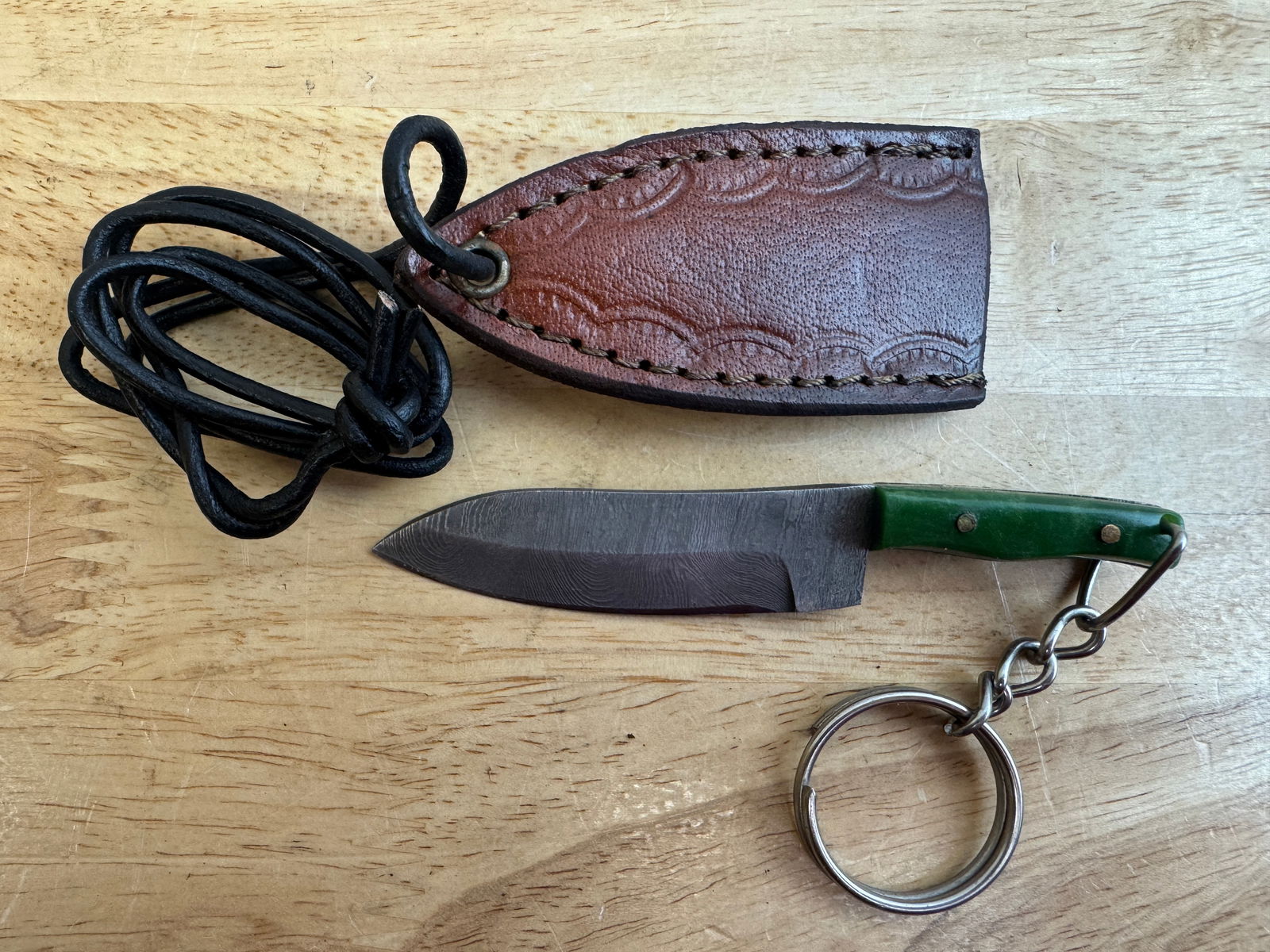 Beautiful Handmade Damascus Steel KeyChain Knife w/Sheath: Beautiful Handmade Damascus Steel Necklace/KeyChain Knife w/Sheath. See photos for details and measurements. Meticulously crafted by skilled artisans, each knife is forged from multiple layers of high
