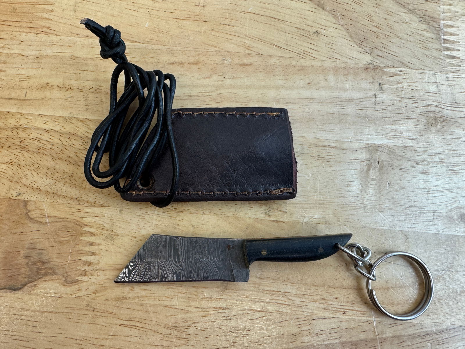 Beautiful Handmade Damascus Steel KeyChain Knife w/Sheath: Beautiful Handmade Damascus Steel Necklace/KeyChain Knife w/Sheath. See photos for details and measurements. Meticulously crafted by skilled artisans, each knife is forged from multiple layers of high