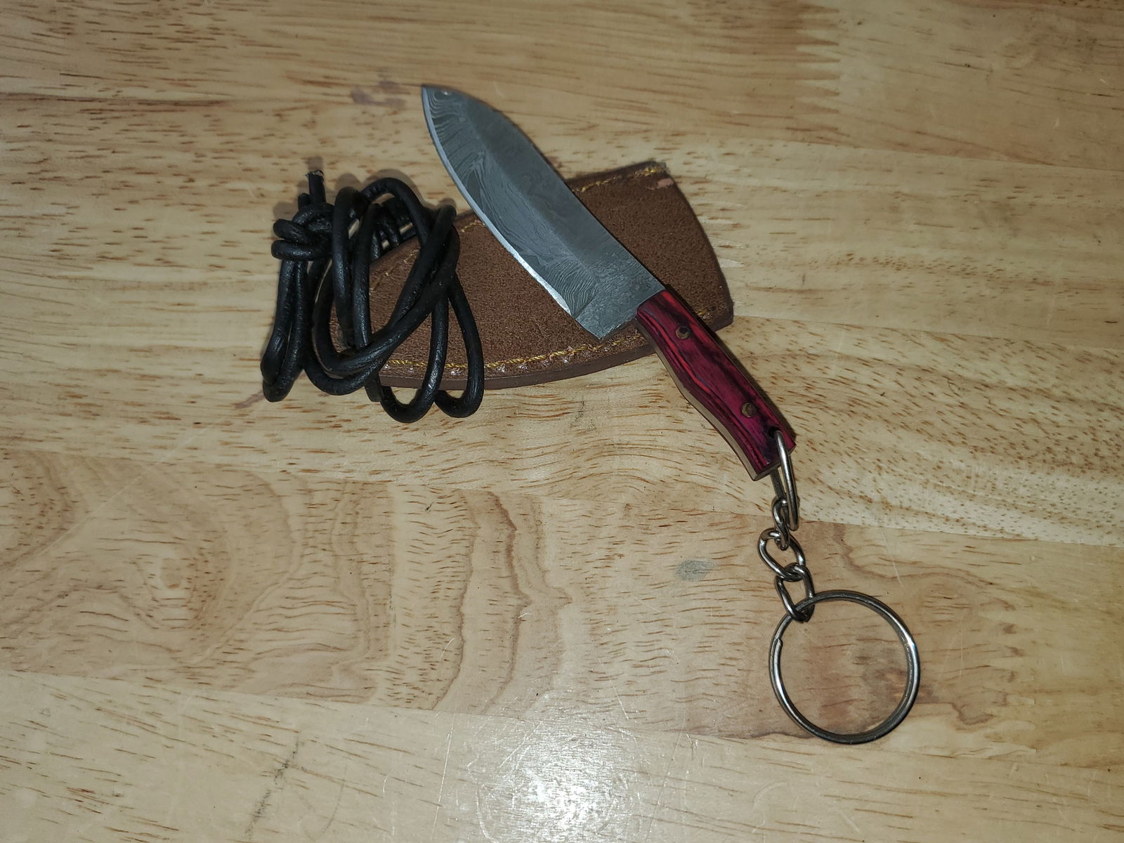 Beautiful Handmade Damascus Steel KeyChain Knife w/Sheath: Beautiful Handmade Damascus Steel Necklace/KeyChain Knife w/Sheath. See photos for details and measurements. Meticulously crafted by skilled artisans, each knife is forged from multiple layers of high