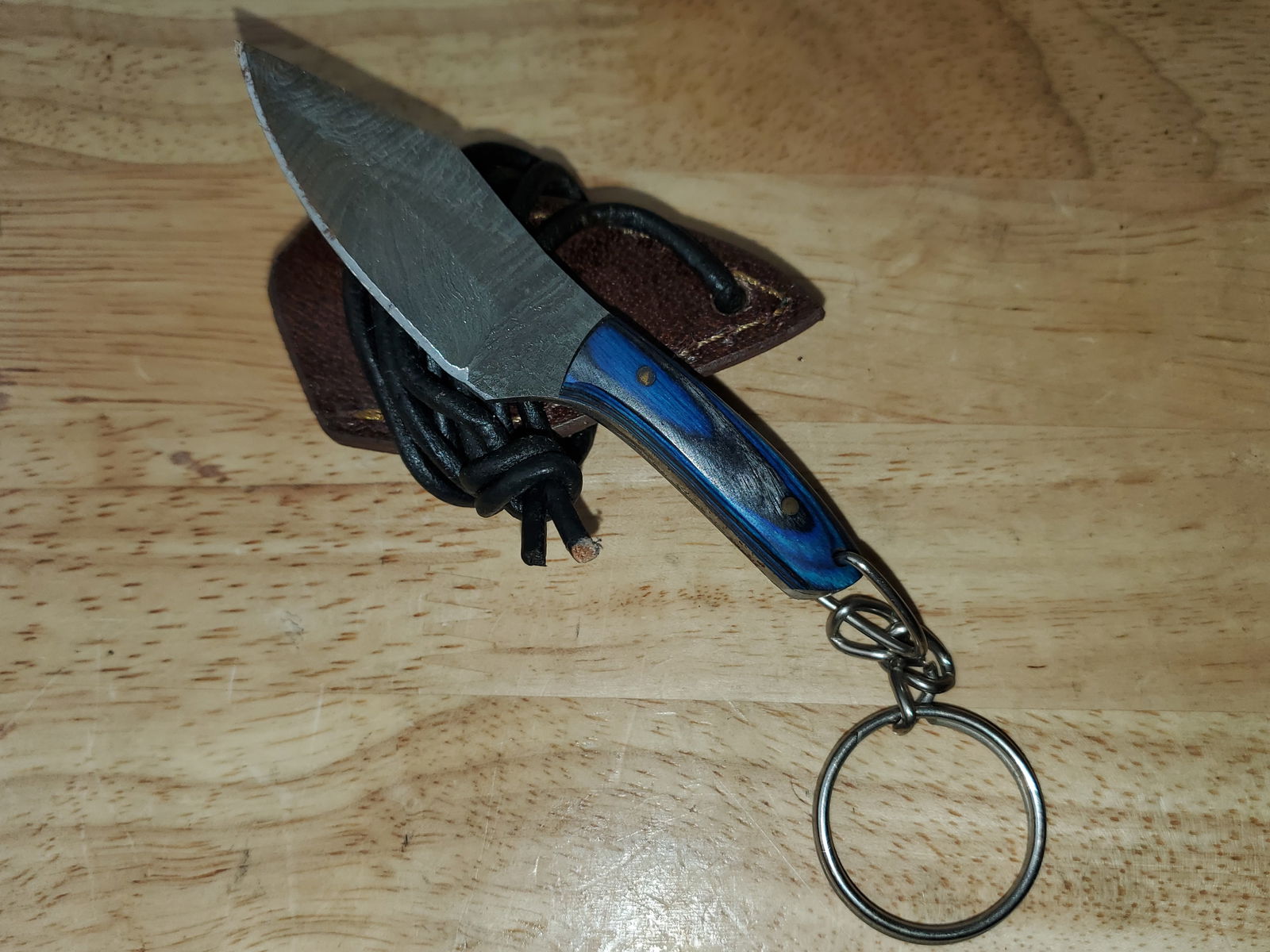 Beautiful Handmade Damascus Steel KeyChain Knife w/Sheath: Beautiful Handmade Damascus Steel Necklace/KeyChain Knife w/Sheath. See photos for details and measurements. Meticulously crafted by skilled artisans, each knife is forged from multiple layers of high