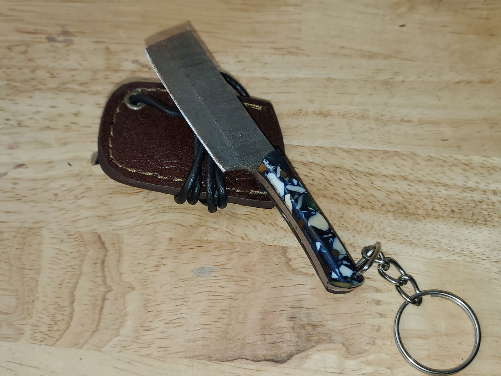 Beautiful Handmade Damascus Steel KeyChain Knife w/Sheath: Beautiful Handmade Damascus Steel Necklace/KeyChain Knife w/Sheath. See photos for details and measurements. Meticulously crafted by skilled artisans, each knife is forged from multiple layers of high