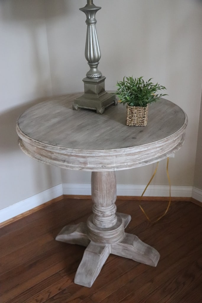 SIDE TABLE: A MODERN ROUND TOP PEDASTAL SIDE TABLE WITH THE DISTRESSED PAINT. VERY GOOD CONDITION. 