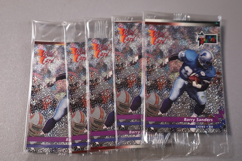 FOOTBALL PACKS: A GROUP OF 5 PACKS OF WILD CARD PROMO PACKS WITH BARRY SANDERS ON TOP. SEALED.