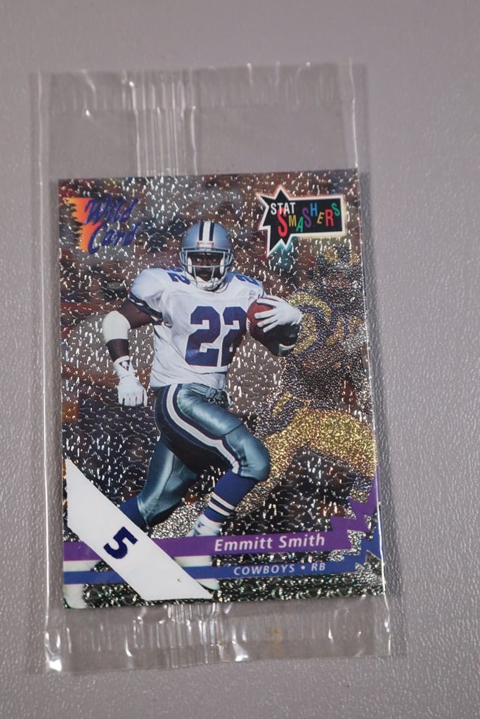 FOOTBALL PACKS: A PAKC OF WILD CARD PROMO CARDS WITH AN EMMITT SMITH 5 STRIPE PARALLE ON TOP. SEALED.