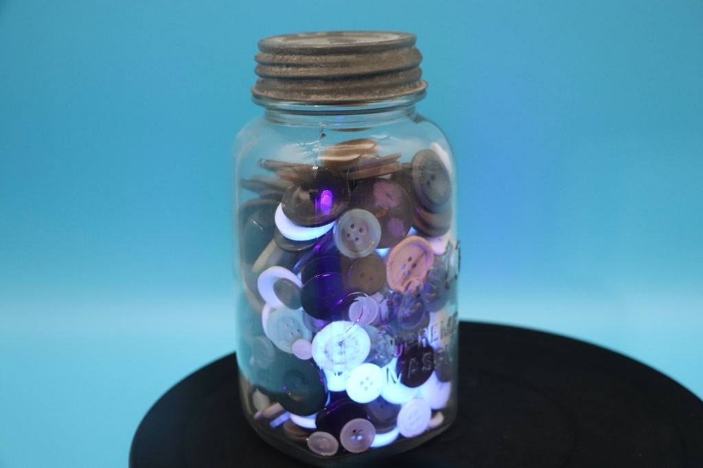 VINTAGE BUTTONS: A LARGE JAR FILLED WITH VINTAGE MEDIUM TO LARGE BUTTONS. SOME GLOW UNDER UV. VERY GOOD CONDITION.
