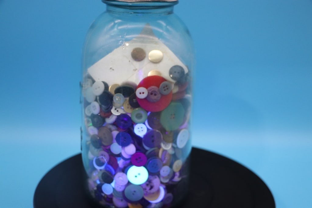 VINTAGE BUTTONS: A LARGE JAR FILLED WITH SMALL TO MEDIUM BUTTONS. SOME GLOW UNDER UV. VERY GOOD CONDITION.