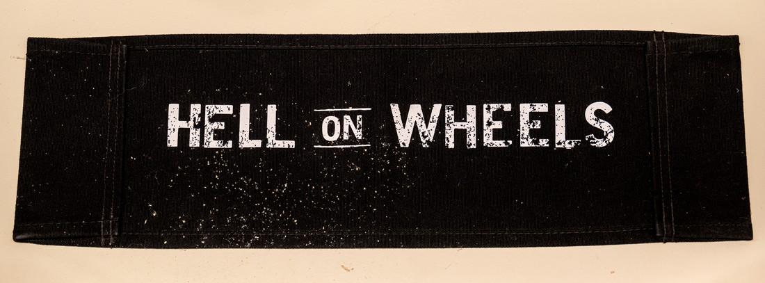 Hell on Wheels chair back: Leon Ingulsrud's chair back from Hell on Wheels. Comes with COA from Hell on Wheels Production, signed by Executive Producers. Estimate $100 - $150