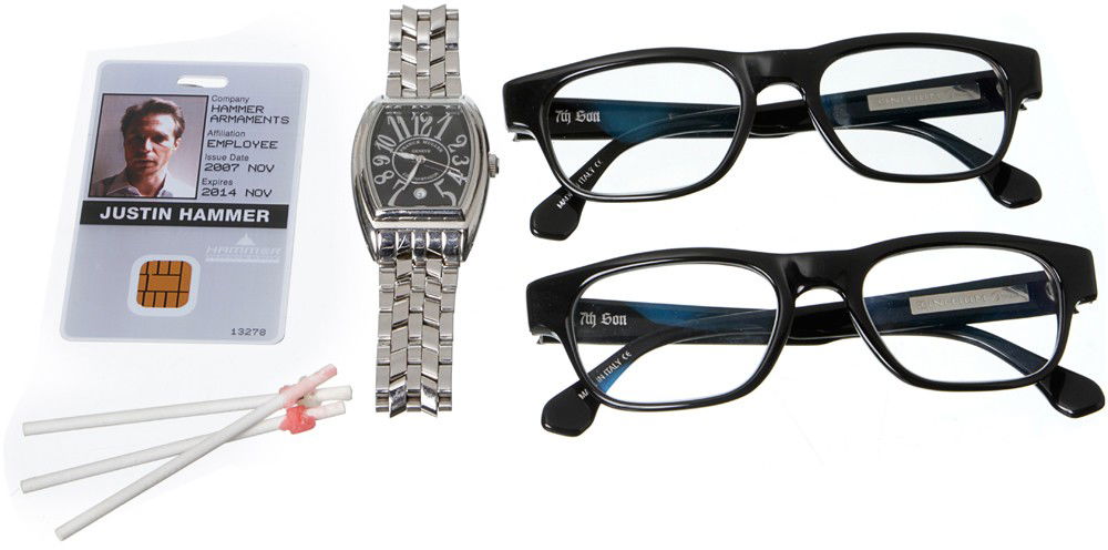 Iron Man 2 Justin Hammer Hero Personal Items: Production Description: Set of two hero black glasses with a light tint by FRANCK MULLER, three used lollipop sticks, one personal Hammer Industries ID card and silver square faced watch. These items