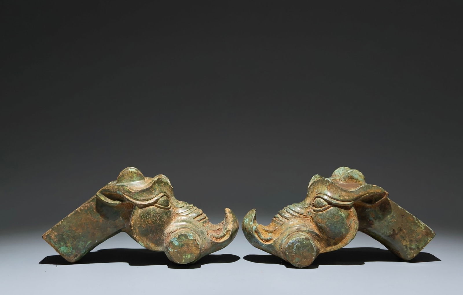 A Pair of Archaic Bronze Dragon-head Ornaments: A Pair of Archaic Bronze Dragon-head Ornaments,the Warring States period in China,Size:3.9inx8.3inx3.5in 一对青铜龙首摆件,中国战ࢲ