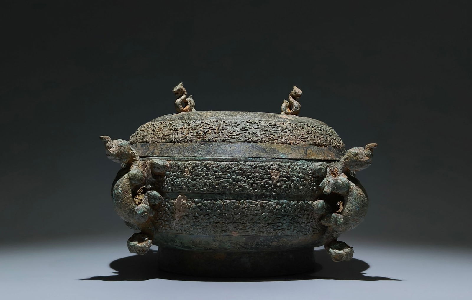 An Archaic Bronze Dragon Pattern Cover Basin,With Inscription: An Archaic Bronze Dragon Pattern Cover Basin,With Inscription,the Warring States period in China,Size:7.5inx13.8inx9.8in 青铜龙纹盖盆,带铭文,È