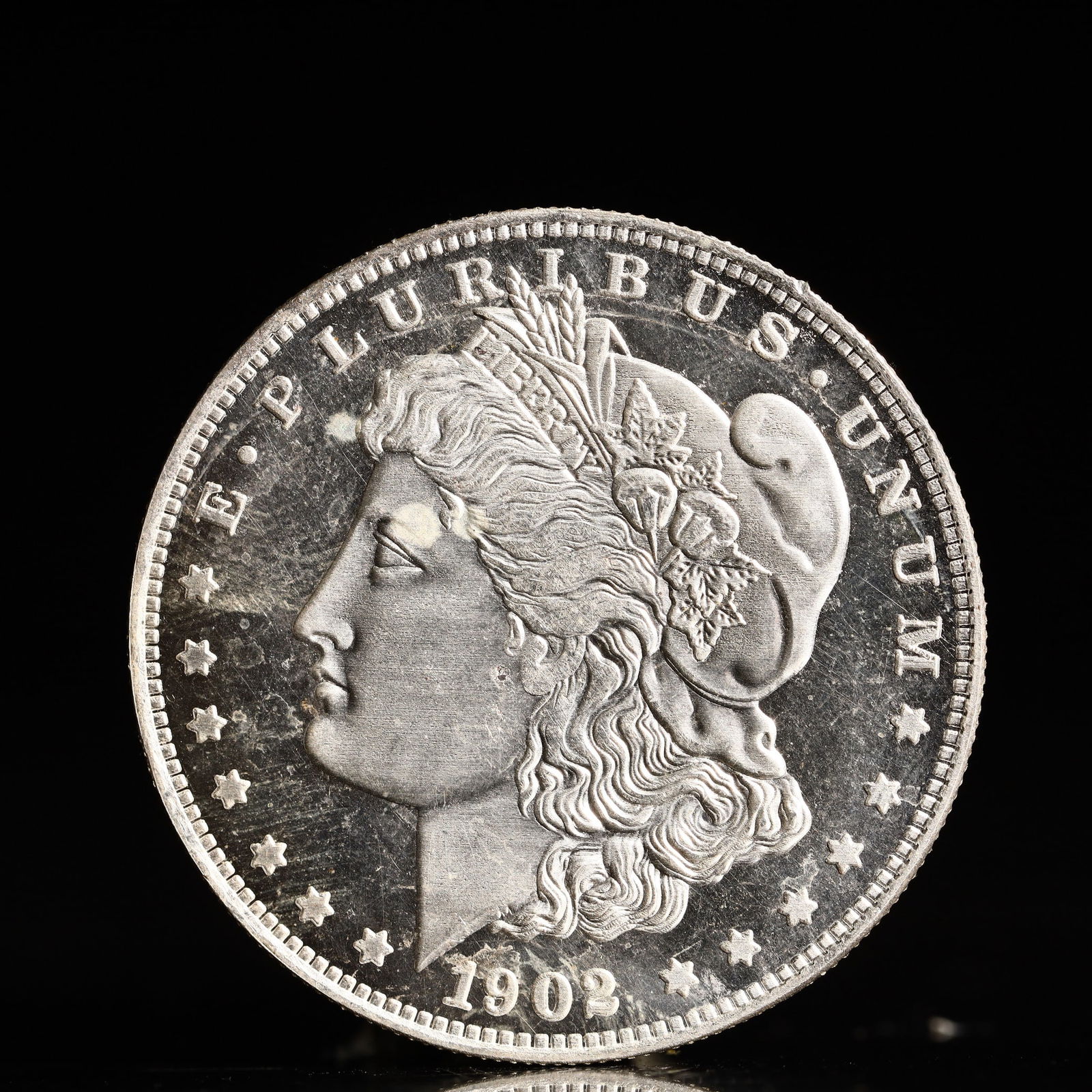 USA Morgan Dollar 1902 Coin: Obv: profile bust with date below and E PLURIBUS UNUM legend and stars around. Rev: eagle with In God we trust above within wreath with UNITED STATES OF AMERICA ONE DOLLAR legend. IN GOD WE TRUST / LI