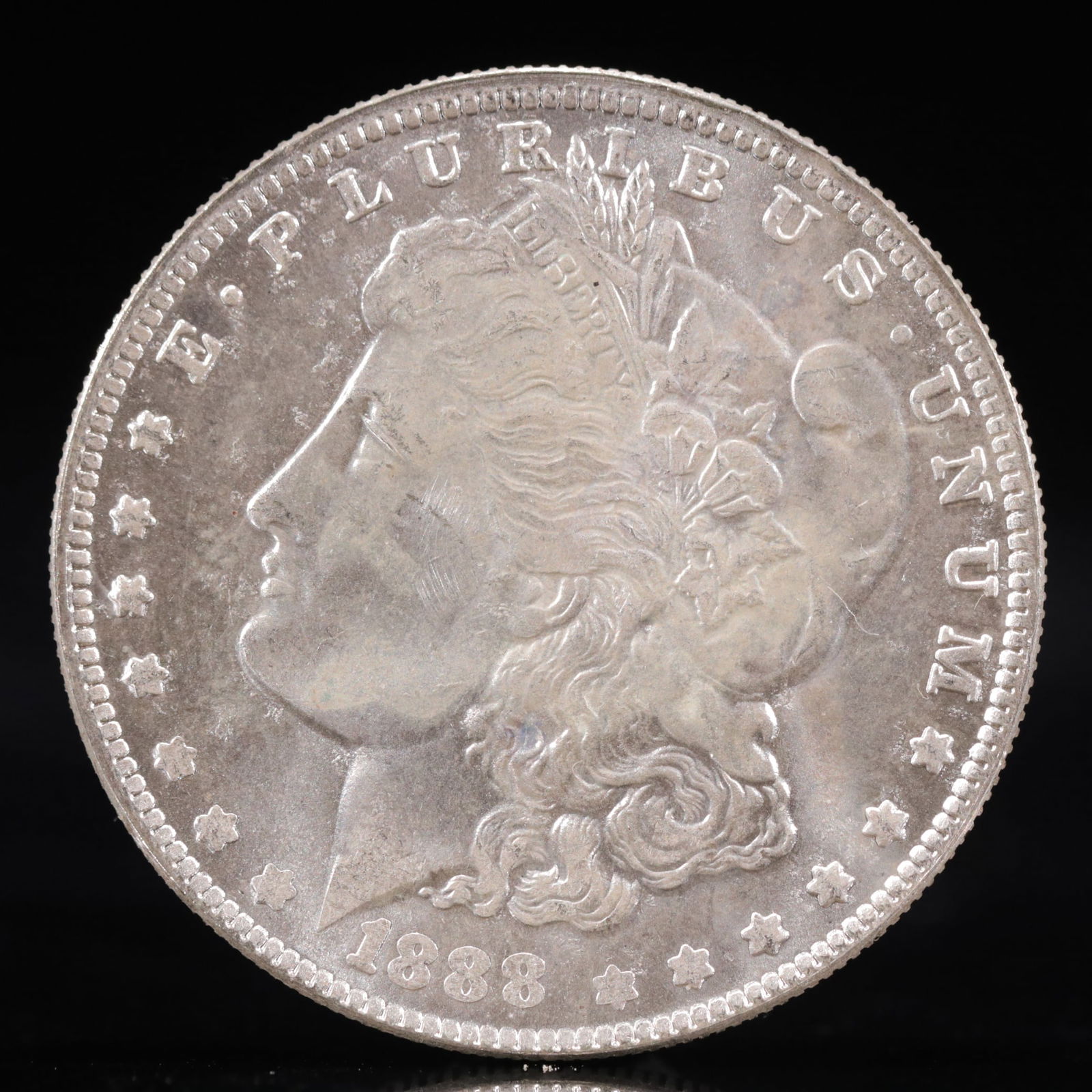 USA Morgan Dollar 1888 Coin: Obv: profile bust with date below and E PLURIBUS UNUM legend and stars around. Rev: eagle with In God we trust above within wreath with UNITED STATES OF AMERICA ONE DOLLAR legend. IN GOD WE TRUST /