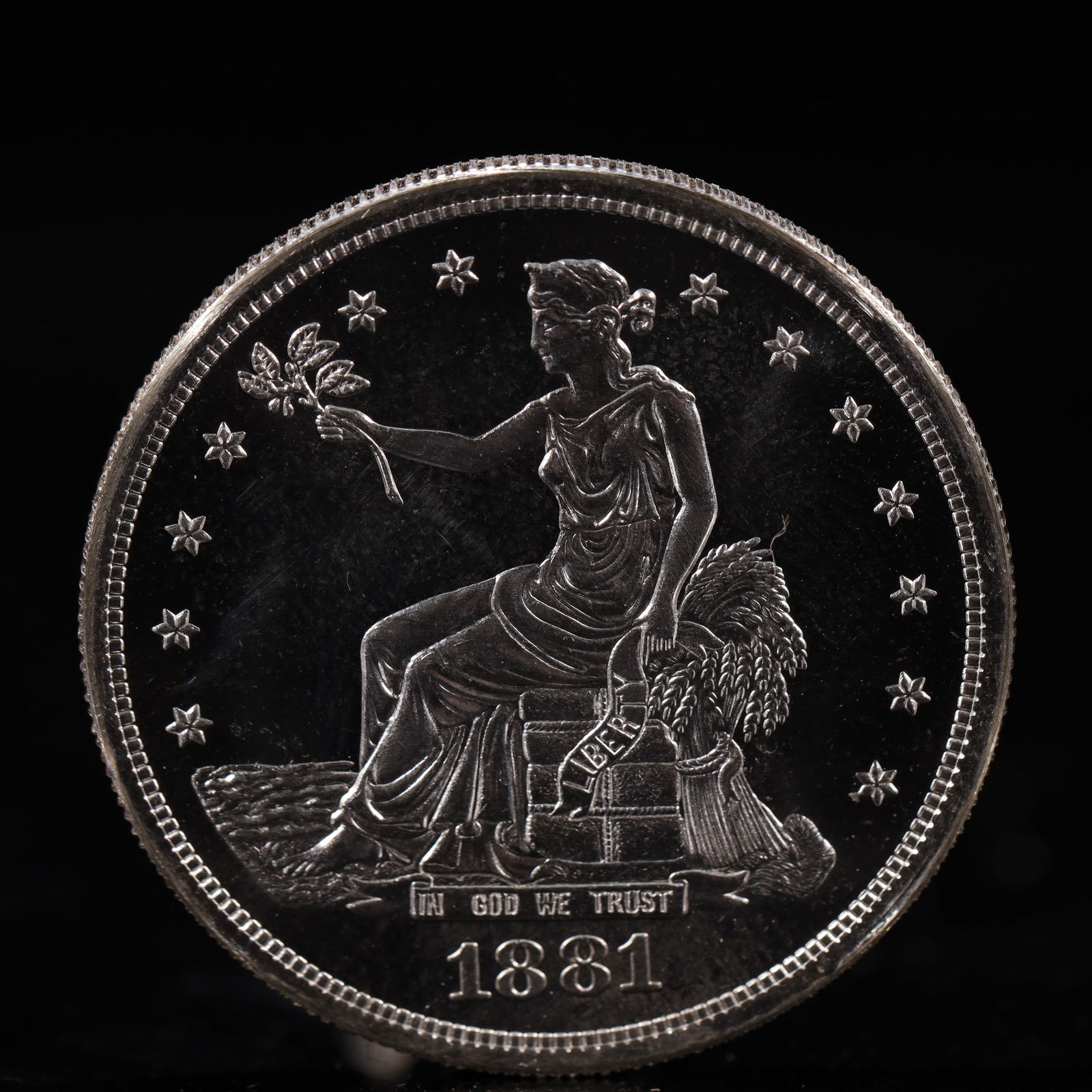 USA Trade Dollar 1881 Coin: American coin. Obverse: Liberty seated on a pedestal facing the sea to the left holding olive branches surrounded by 13 stars. IN GOD WE TRUST / LIBERTY / 1881. Reverse: An eagle holding branches with