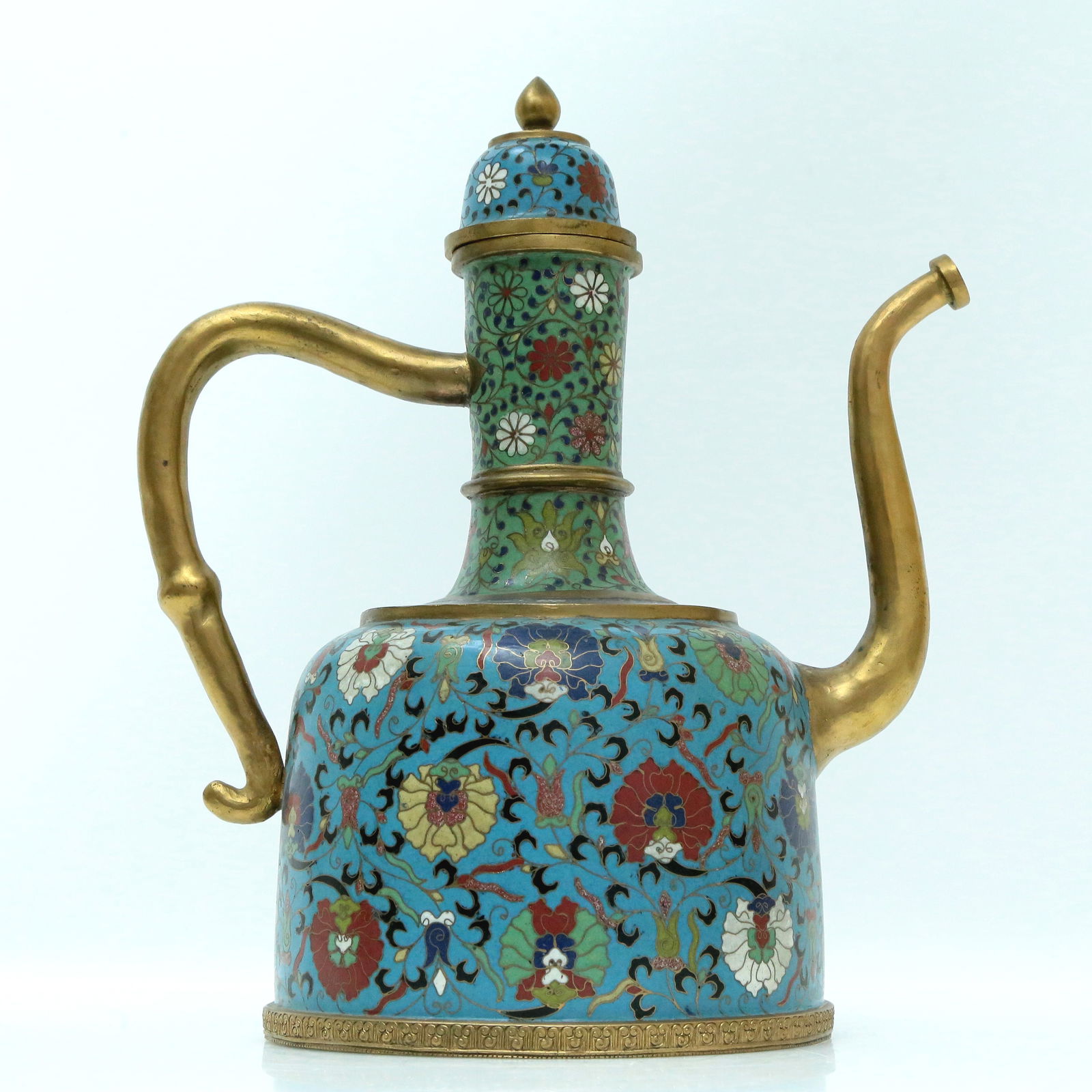 A Fine Cloisonne 'Scrolling Lotus' Ewer: A Fine Cloisonne 'Scrolling Lotus' Ewer. Enameled with polychrome floral scrolls, all reserved on a bright turquoise ground, topknot surmounted by a teardrop-form finial. Chinese Qing Dynasty. Size:10
