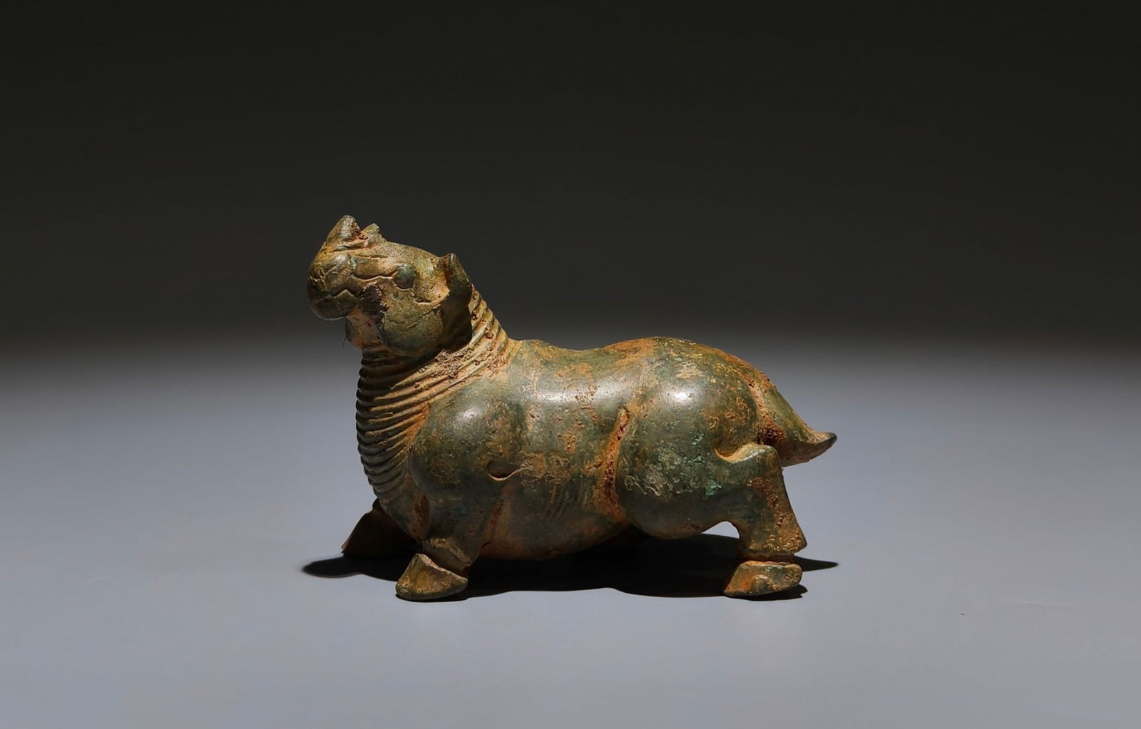 An Archaic Bronze Rhinoceros Ornament: An Archaic Bronze Rhinoceros Ornament,Han Dynasty, China,Size:2.4inx3.5inx1.6in 青铜犀牛摆件,中国汉代
