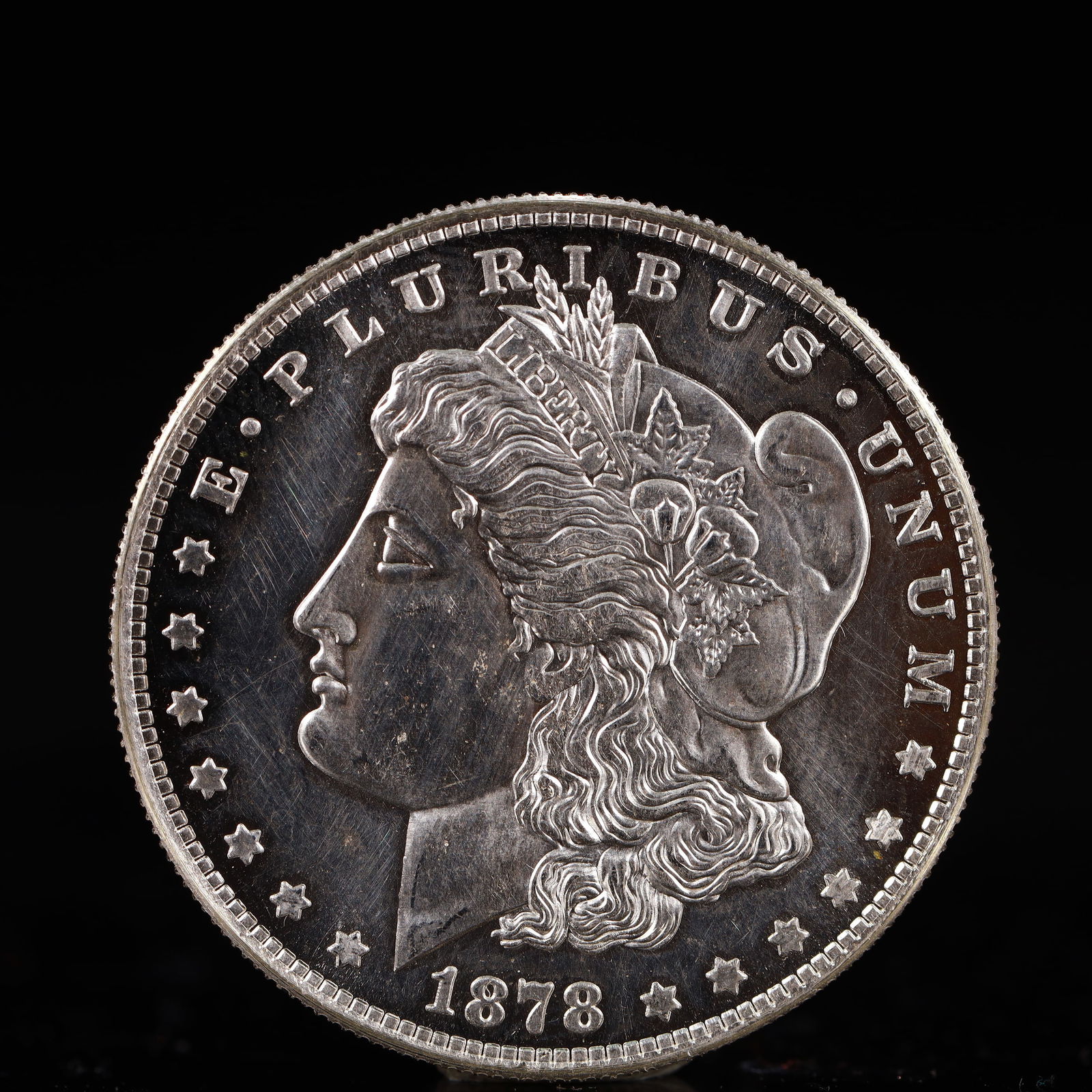 USA Morgan Dollar 1878 Coin: Obv: profile bust with date below and E PLURIBUS UNUM legend and stars around. Rev: eagle with In God we trust above within wreath with UNITED STATES OF AMERICA ONE DOLLAR legend. IN GOD WE TRUST /