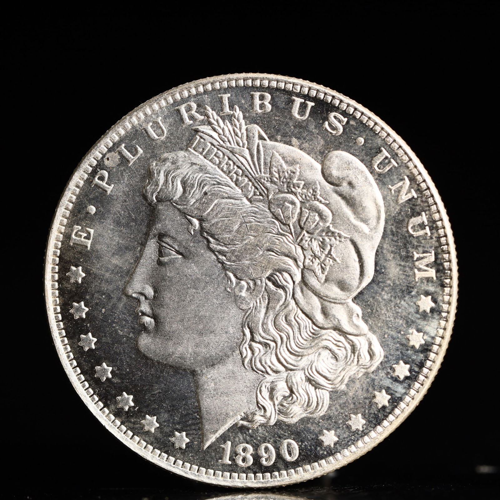USA Morgan Dollar 1890 Coin: Obv: profile bust with date below and E PLURIBUS UNUM legend and stars around. Rev: eagle with In God we trust above within wreath with UNITED STATES OF AMERICA ONE DOLLAR legend. IN GOD WE TRUST / LI