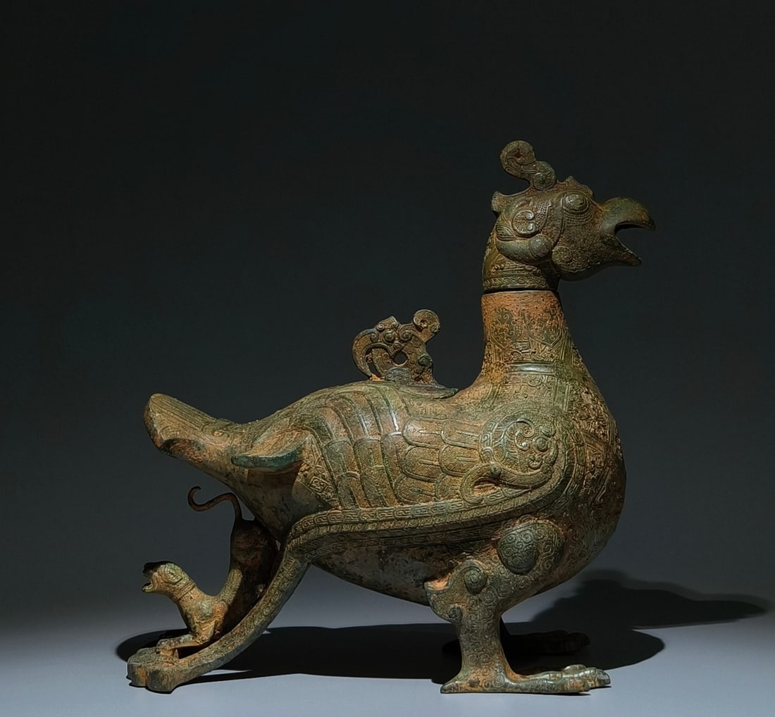 An Archaic Bronze Coiled Serpent Pattern Beast Tail Bird-Shaped Zun,With Inscription: An Archaic Bronze Coiled Serpent Pattern Beast Tail Bird-Shaped Zun,With Inscription,the Warring States period in China,Size:14.2inx13.4inx7.5in 