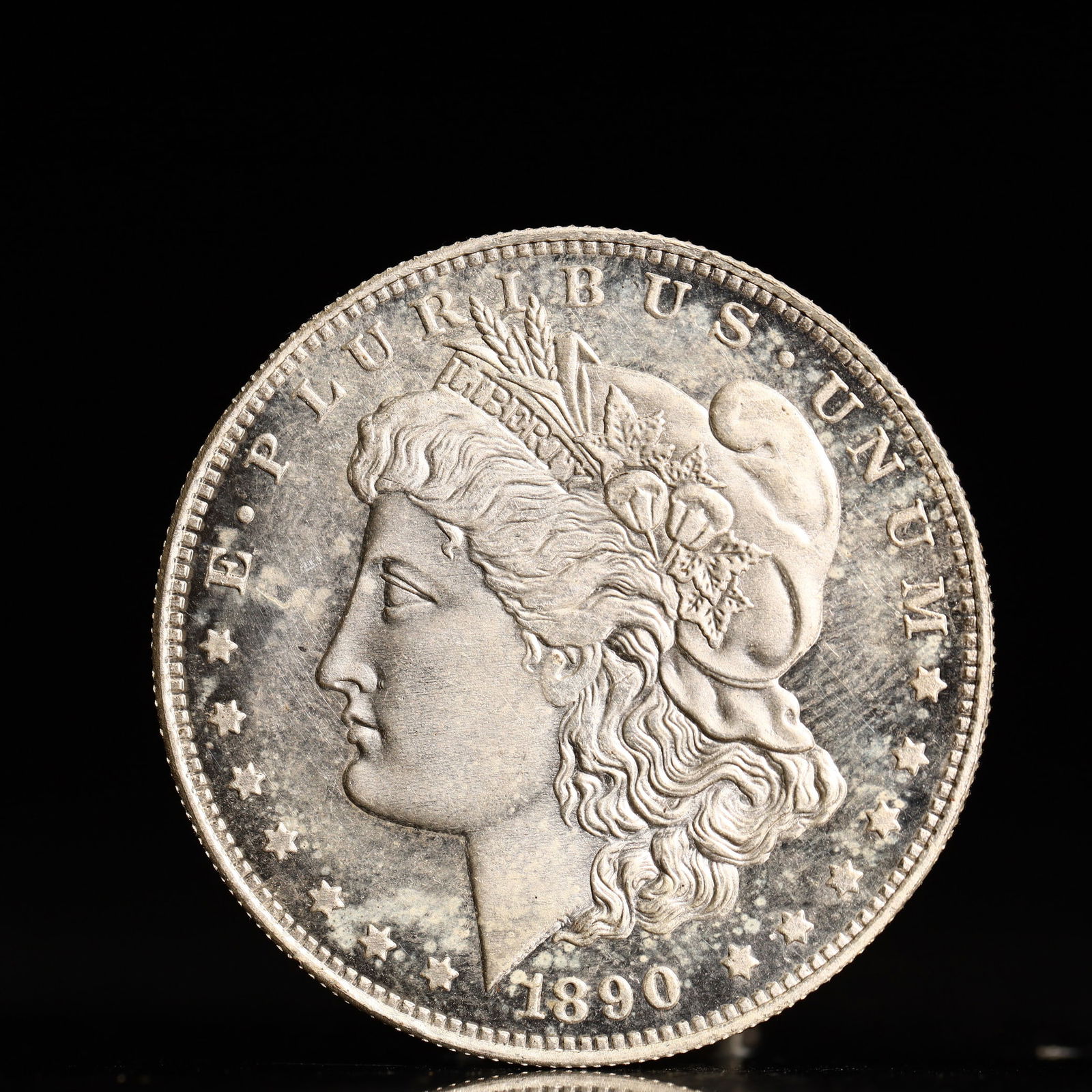 USA Morgan Dollar 1890 Coin: Obv: profile bust with date below and E PLURIBUS UNUM legend and stars around. Rev: eagle with In God we trust above within wreath with UNITED STATES OF AMERICA ONE DOLLAR legend. IN GOD WE TRUST / LI