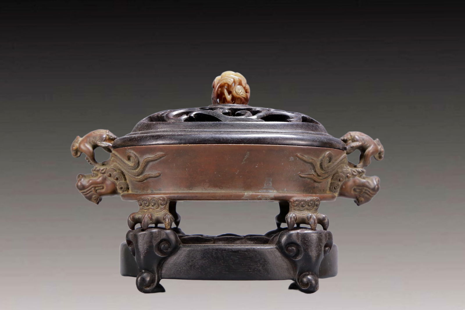 An Archaic Bronze Beast-Ears Censer,with Zitanwood Inlaid White Jade Cover: An Archaic Bronze Beast-Ears Censer,with Zitanwood Inlaid White Jade Cover,Qing Dynasty, China,Daoguang Five-character Mark,Size:8.3inx4.3inx5.5in,Weight:1550g 铜兽耳香炉