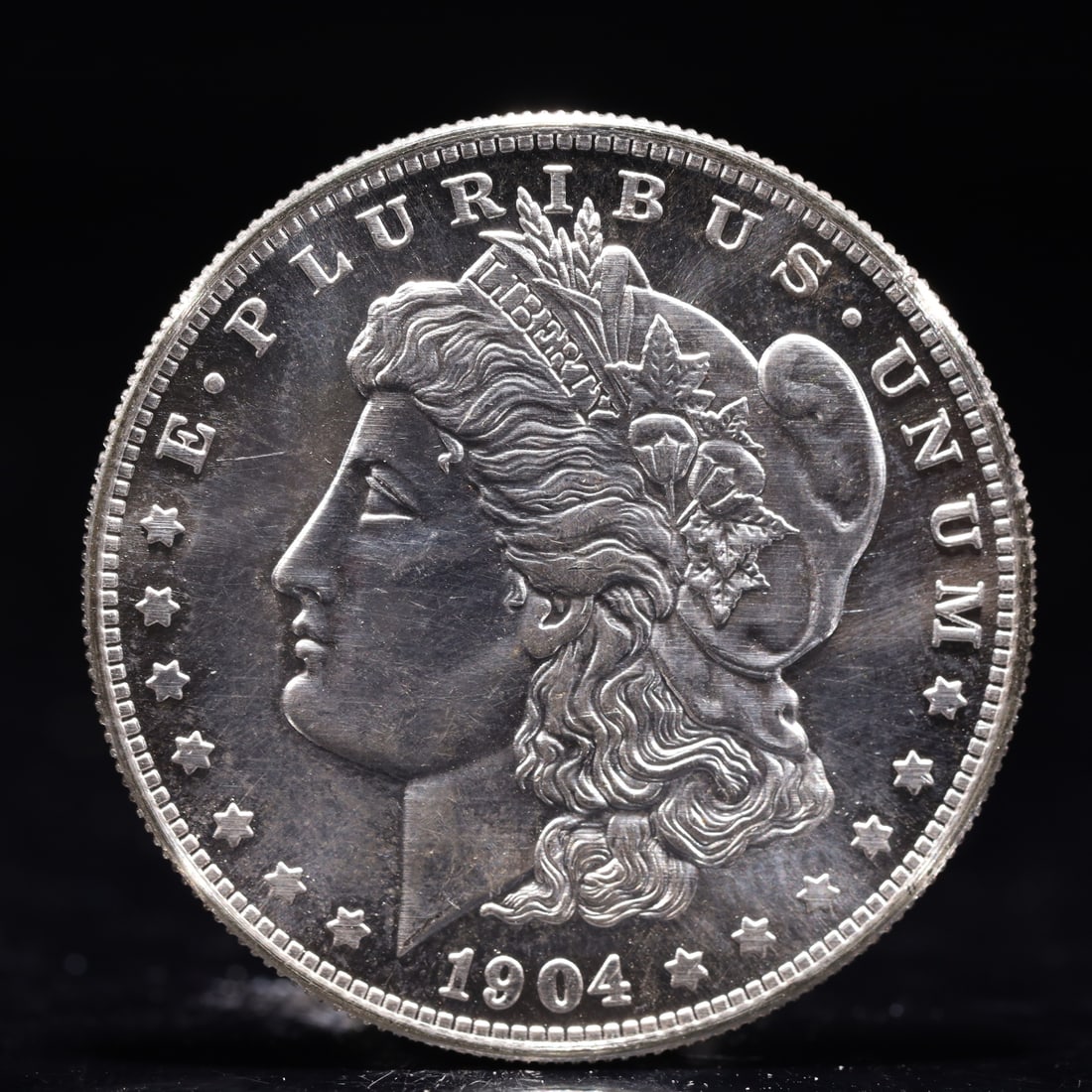 USA Morgan Dollar 1904 Coin: Obv: profile bust with date below and E PLURIBUS UNUM legend and stars around. Rev: eagle with In God we trust above within wreath with UNITED STATES OF AMERICA ONE DOLLAR legend. IN GOD WE TRUST / LI