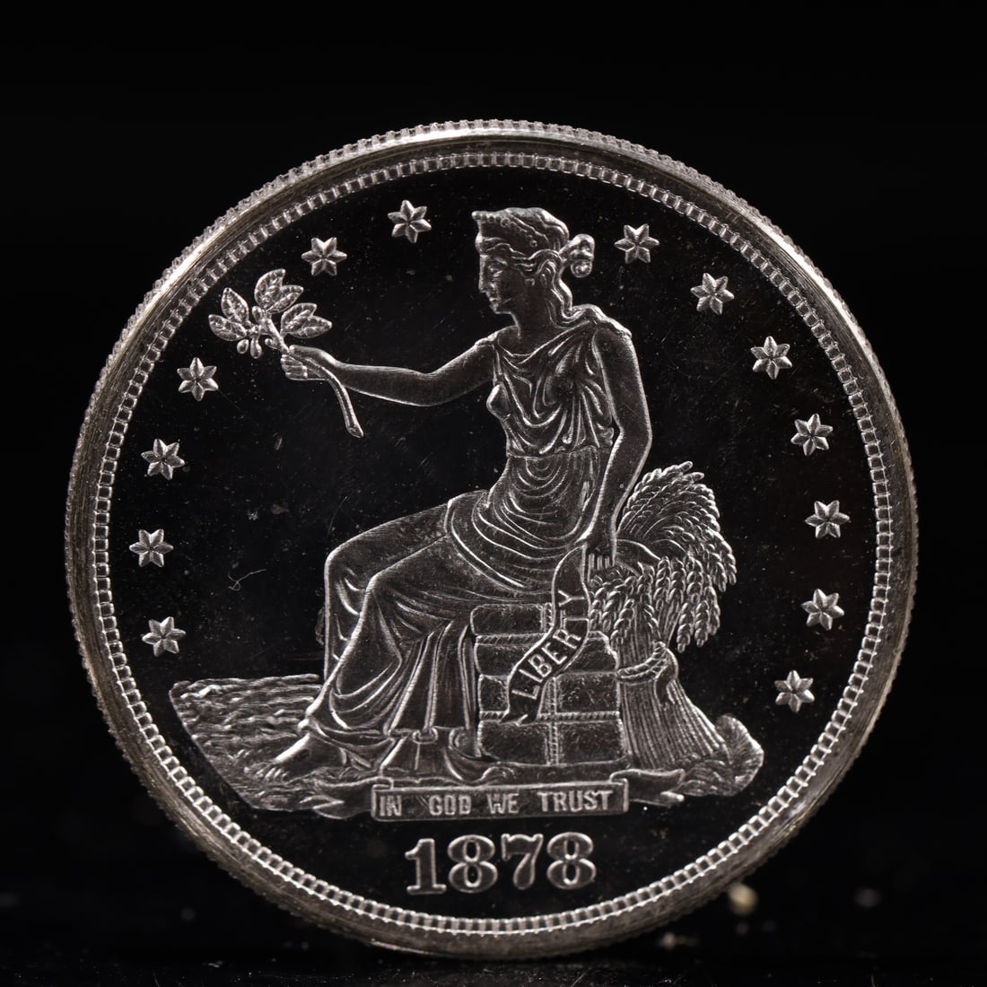 USA Trade Dollar 1878 Coin: American coin. Obverse: Liberty seated on a pedestal facing the sea to the left holding olive branches surrounded by 13 stars. IN GOD WE TRUST / LIBERTY / 1878. Reverse: An eagle holding branches with