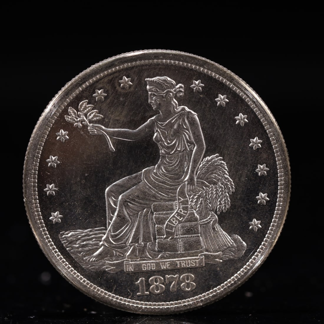 USA Trade Dollar 1878 Coin: American coin. Obverse: Liberty seated on a pedestal facing the sea to the left holding olive branches surrounded by 13 stars. IN GOD WE TRUST / LIBERTY / 1878. Reverse: An eagle holding branches with