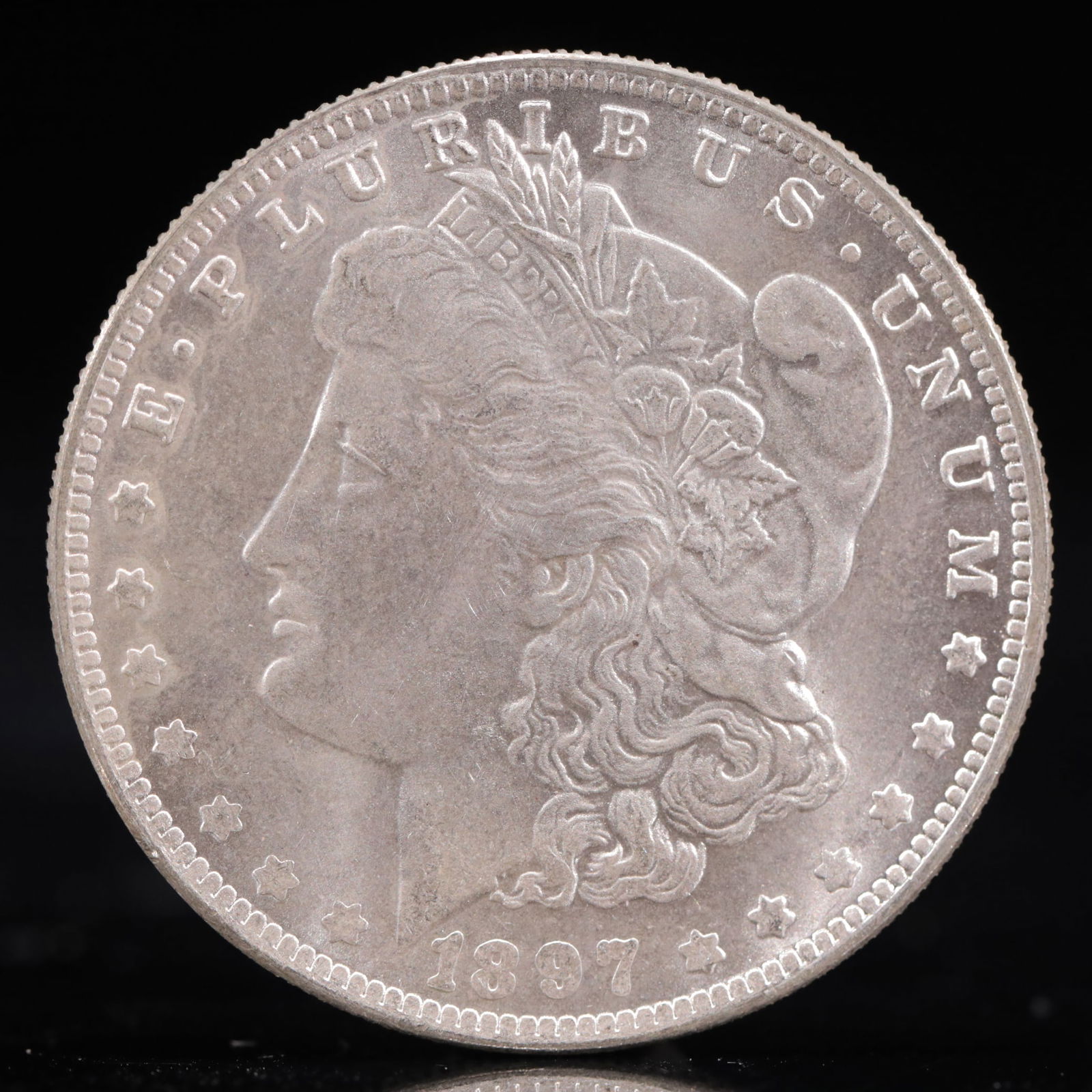USA Morgan Dollar 1897 Coin: Obv: profile bust with date below and E PLURIBUS UNUM legend and stars around. Rev: eagle with In God we trust above within wreath with UNITED STATES OF AMERICA ONE DOLLAR legend. IN GOD WE TRUST / LI