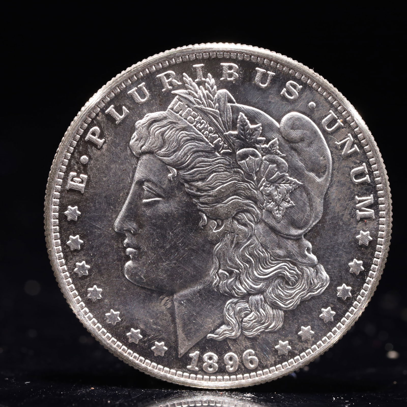 USA Morgan Dollar 1896 Coin: Obv: profile bust with date below and E PLURIBUS UNUM legend and stars around. Rev: eagle with In God we trust above within wreath with UNITED STATES OF AMERICA ONE DOLLAR legend. IN GOD WE TRUST / LI
