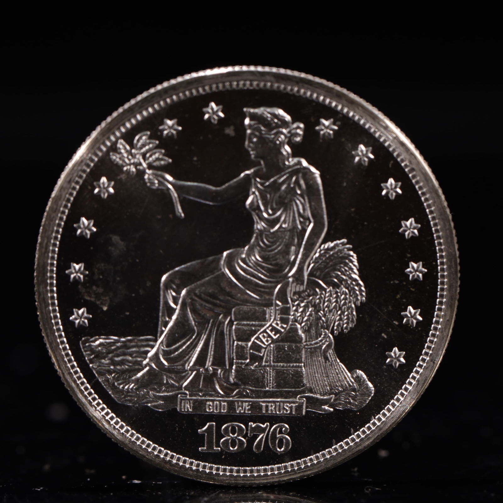USA Trade Dollar 1876 Coin: American coin. Obverse: Liberty seated on a pedestal facing the sea to the left holding olive branches surrounded by 13 stars. IN GOD WE TRUST / LIBERTY / 1876. Reverse: An eagle holding branches