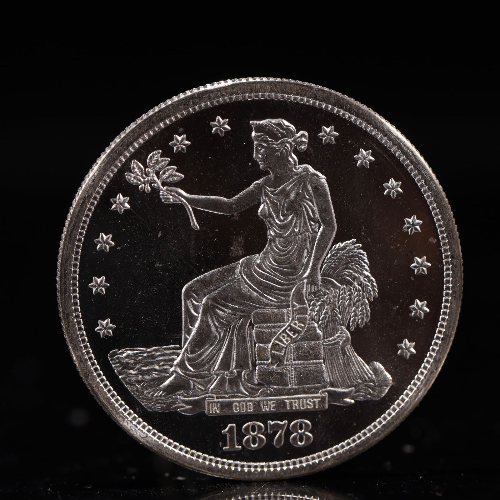 USA Trade Dollar 1878 Coin: American coin. Obverse: Liberty seated on a pedestal facing the sea to the left holding olive branches surrounded by 13 stars. IN GOD WE TRUST / LIBERTY / 1878. Reverse: An eagle holding branches