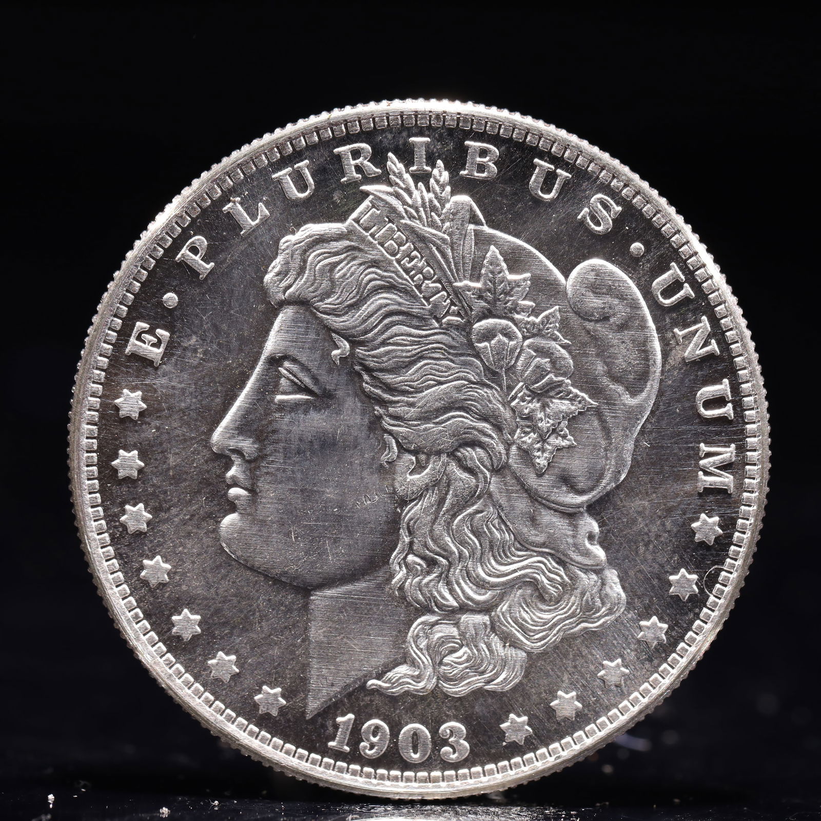 USA Morgan Dollar 1903 Coin: Obv: profile bust with date below and E PLURIBUS UNUM legend and stars around. Rev: eagle with In God we trust above within wreath with UNITED STATES OF AMERICA ONE DOLLAR legend. IN GOD WE TRUST / LI