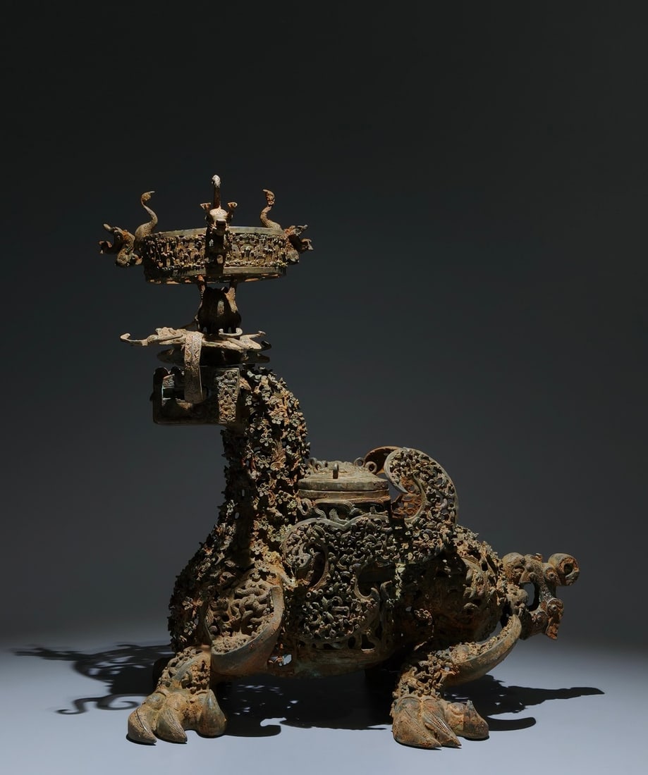 An Archaic Bronze Hollow Plum Blossom Pattern Auspicious Beast-Shaped Candlestick,With Inscription: An Archaic Bronze Hollow Plum Blossom Pattern Auspicious Beast-Shaped Candlestick,With Inscription,the Warring States period in China,Size:17.3inx14.2inx11.8in 青铜镂空梅