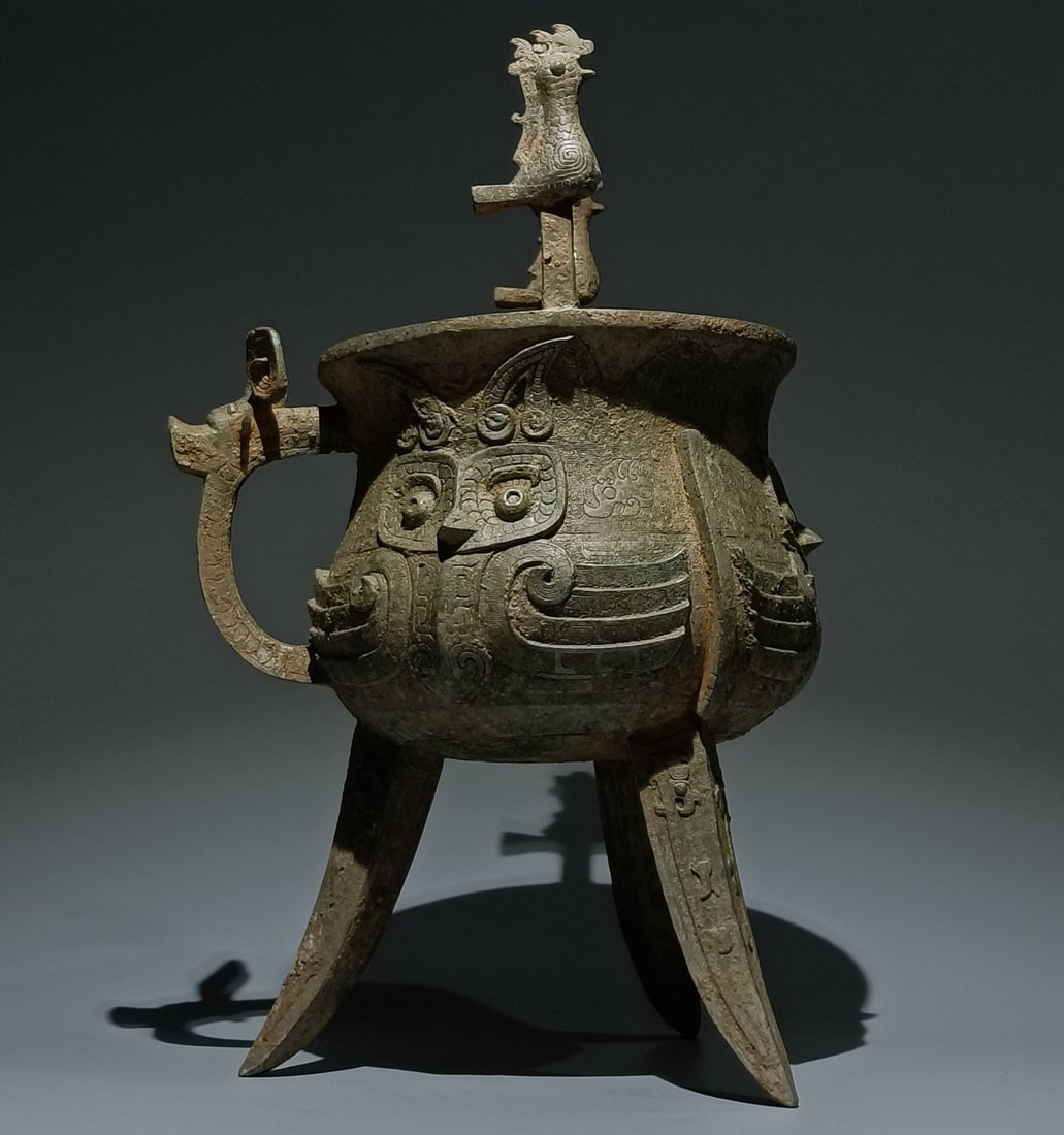 An Archaic Bronze Beast-Face Pattern Bird-Ears Tripod Cup: An Archaic Bronze Beast-Face Pattern Bird-Ears Tripod Cup,the Western Zhou Dynasty in China,Size:16.5inx11inx8.3in 青铜兽面纹鸟耳三足杯,