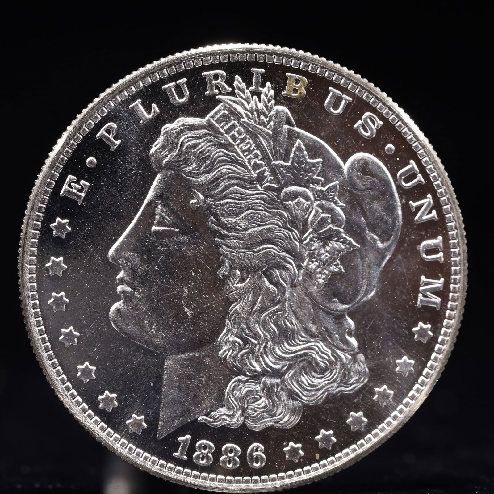 USA Morgan Dollar 1886 Coin: Obv: profile bust with date below and E PLURIBUS UNUM legend and stars around. Rev: eagle with In God we trust above within wreath with UNITED STATES OF AMERICA ONE DOLLAR legend. IN GOD WE TRUST / LI