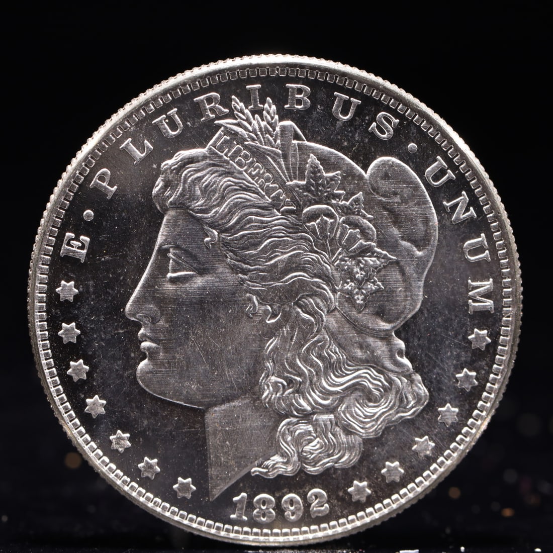 USA Morgan Dollar 1892 Coin: Obv: profile bust with date below and E PLURIBUS UNUM legend and stars around. Rev: eagle with In God we trust above within wreath with UNITED STATES OF AMERICA ONE DOLLAR legend. IN GOD WE TRUST / LI
