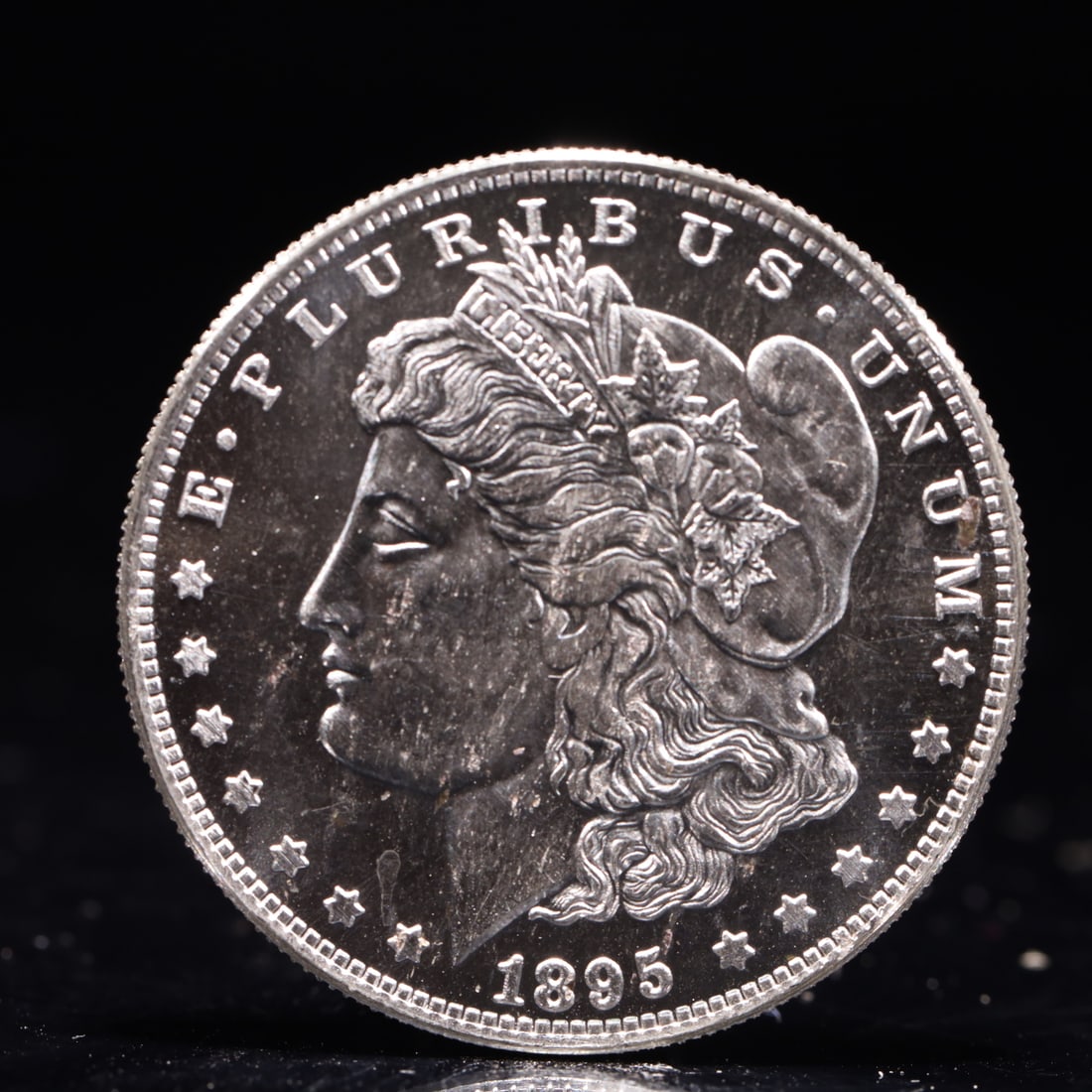 USA Morgan Dollar 1895 Coin: Obv: profile bust with date below and E PLURIBUS UNUM legend and stars around. Rev: eagle with In God we trust above within wreath with UNITED STATES OF AMERICA ONE DOLLAR legend. IN GOD WE TRUST / LI