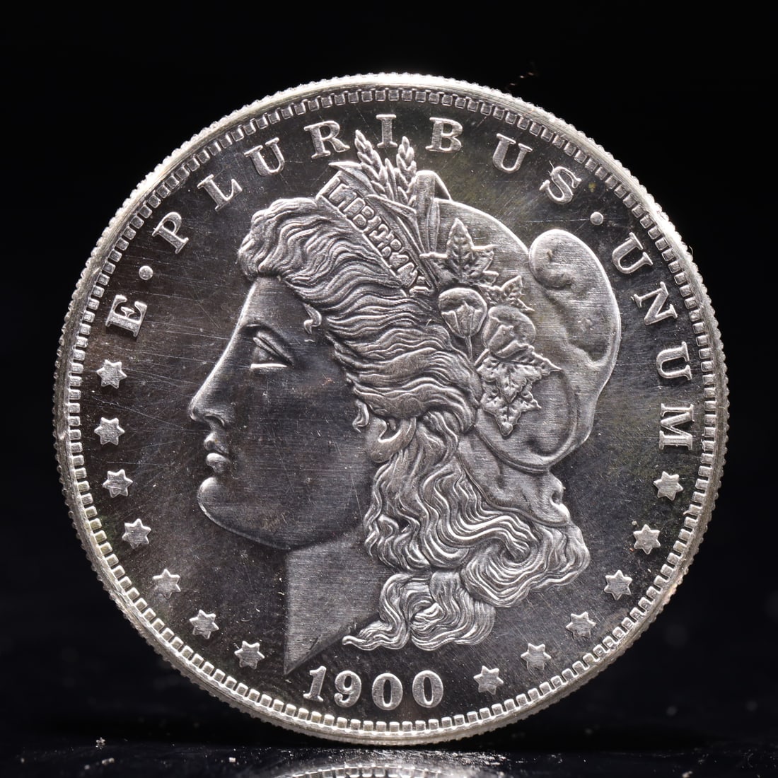 USA Morgan Dollar 1900 Coin: Obv: profile bust with date below and E PLURIBUS UNUM legend and stars around. Rev: eagle with In God we trust above within wreath with UNITED STATES OF AMERICA ONE DOLLAR legend. IN GOD WE TRUST / LI