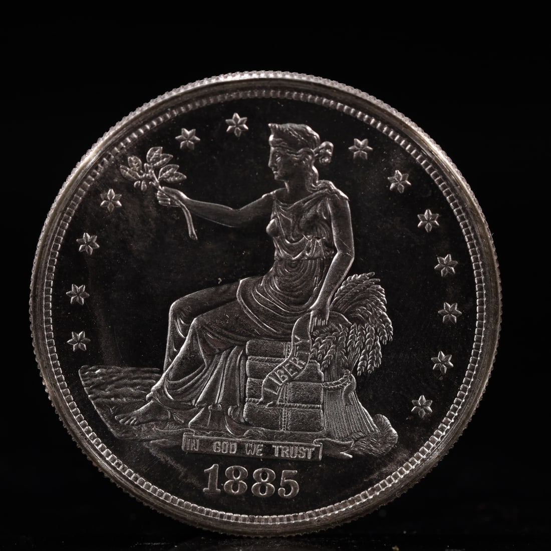 USA Trade Dollar 1885 Coin: American coin. Obverse: Liberty seated on a pedestal facing the sea to the left holding olive branches surrounded by 13 stars. IN GOD WE TRUST / LIBERTY / 1885. Reverse: An eagle holding branches with