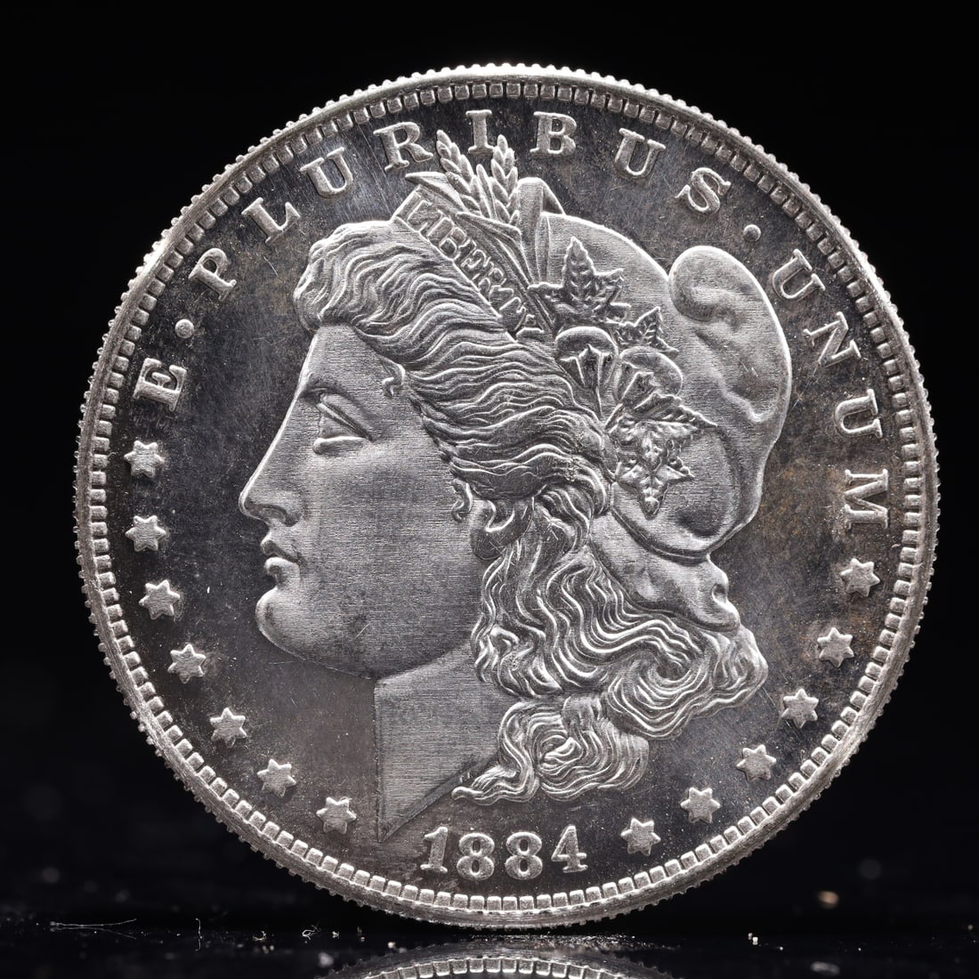 USA Morgan Dollar 1884 Coin: Obv: profile bust with date below and E PLURIBUS UNUM legend and stars around. Rev: eagle with In God we trust above within wreath with UNITED STATES OF AMERICA ONE DOLLAR legend. IN GOD WE TRUST / LI