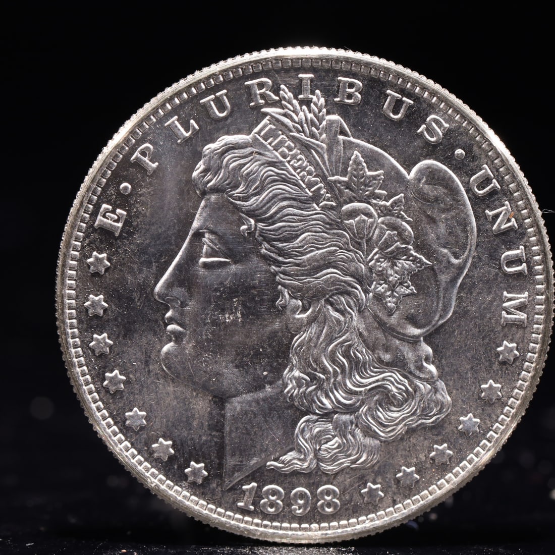 USA Morgan Dollar 1898 Coin: Obv: profile bust with date below and E PLURIBUS UNUM legend and stars around. Rev: eagle with In God we trust above within wreath with UNITED STATES OF AMERICA ONE DOLLAR legend. IN GOD WE TRUST /
