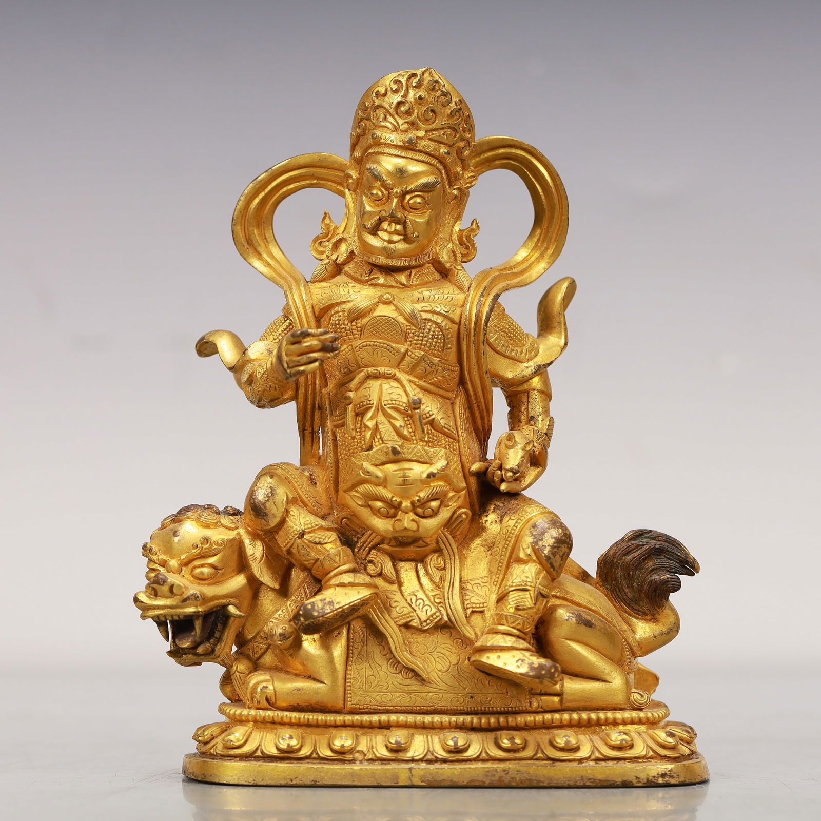 An Excellent Gilt-Bronze Figure Of Vaishravana: An Excellent Gilt-Bronze Figure Of Vaishravana. Seated with a dignified expression,body rendered clad in an armor,face cast with rounded,bulging eyes,also wearing a celestial scarf. Chinese Qing