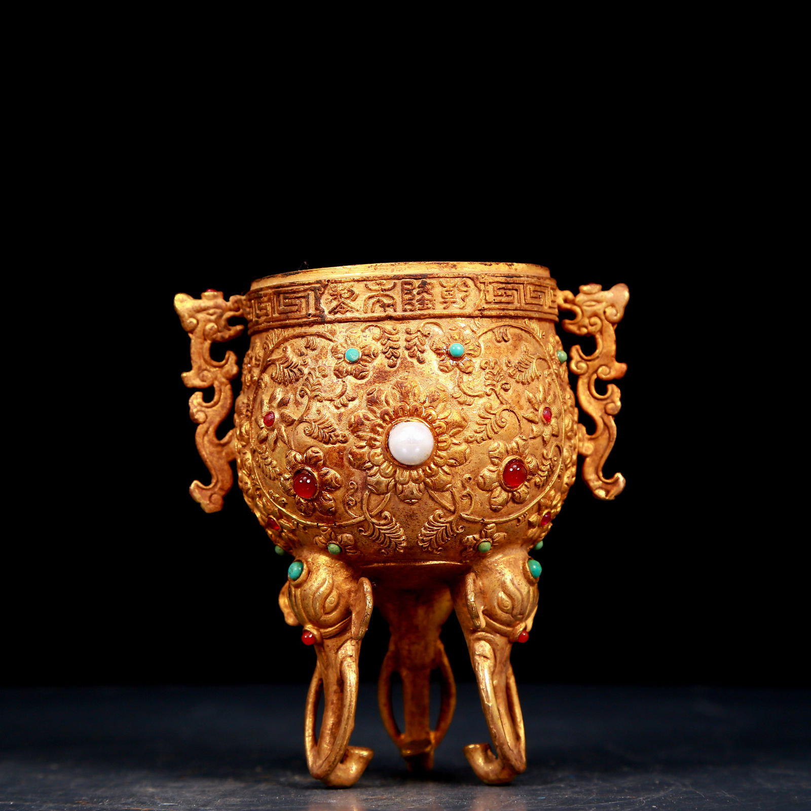 An exquisite gilt bronze cup with double ears, tripod and dragon pattern inlaid with gems: An exquisite gilt bronze cup with double ears and tripod and a dragon pattern inlaid with gems, , Qing Dynasty, China. The surface has been carefully carved, vividly demonstrating the superb skills of