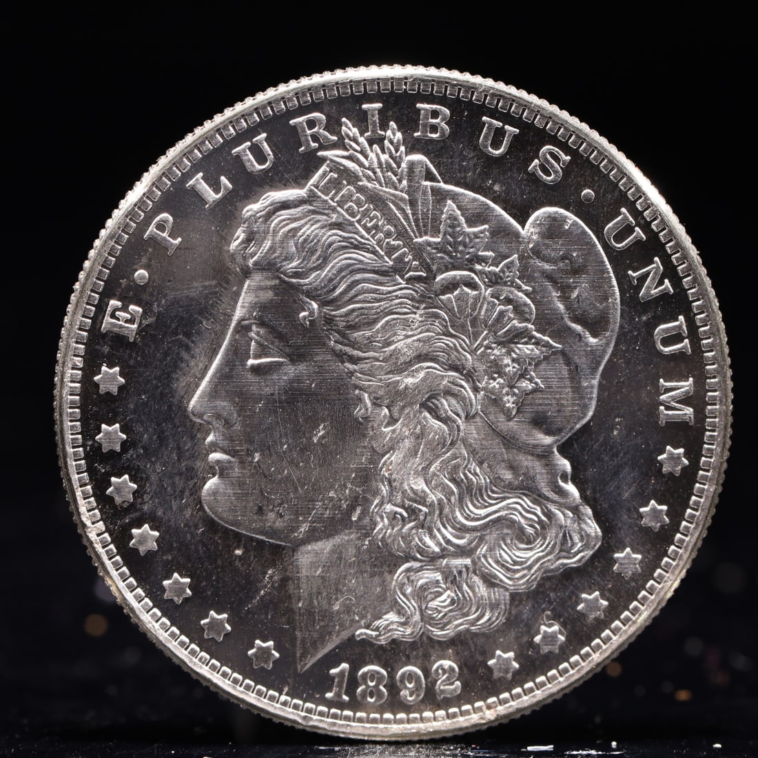 USA Morgan Dollar 1892 Coin: Obv: profile bust with date below and E PLURIBUS UNUM legend and stars around. Rev: eagle with In God we trust above within wreath with UNITED STATES OF AMERICA ONE DOLLAR legend. IN GOD WE TRUST / LI