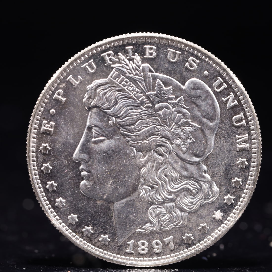 USA Morgan Dollar 1897 Coin: Obv: profile bust with date below and E PLURIBUS UNUM legend and stars around. Rev: eagle with In God we trust above within wreath with UNITED STATES OF AMERICA ONE DOLLAR legend. IN GOD WE TRUST /