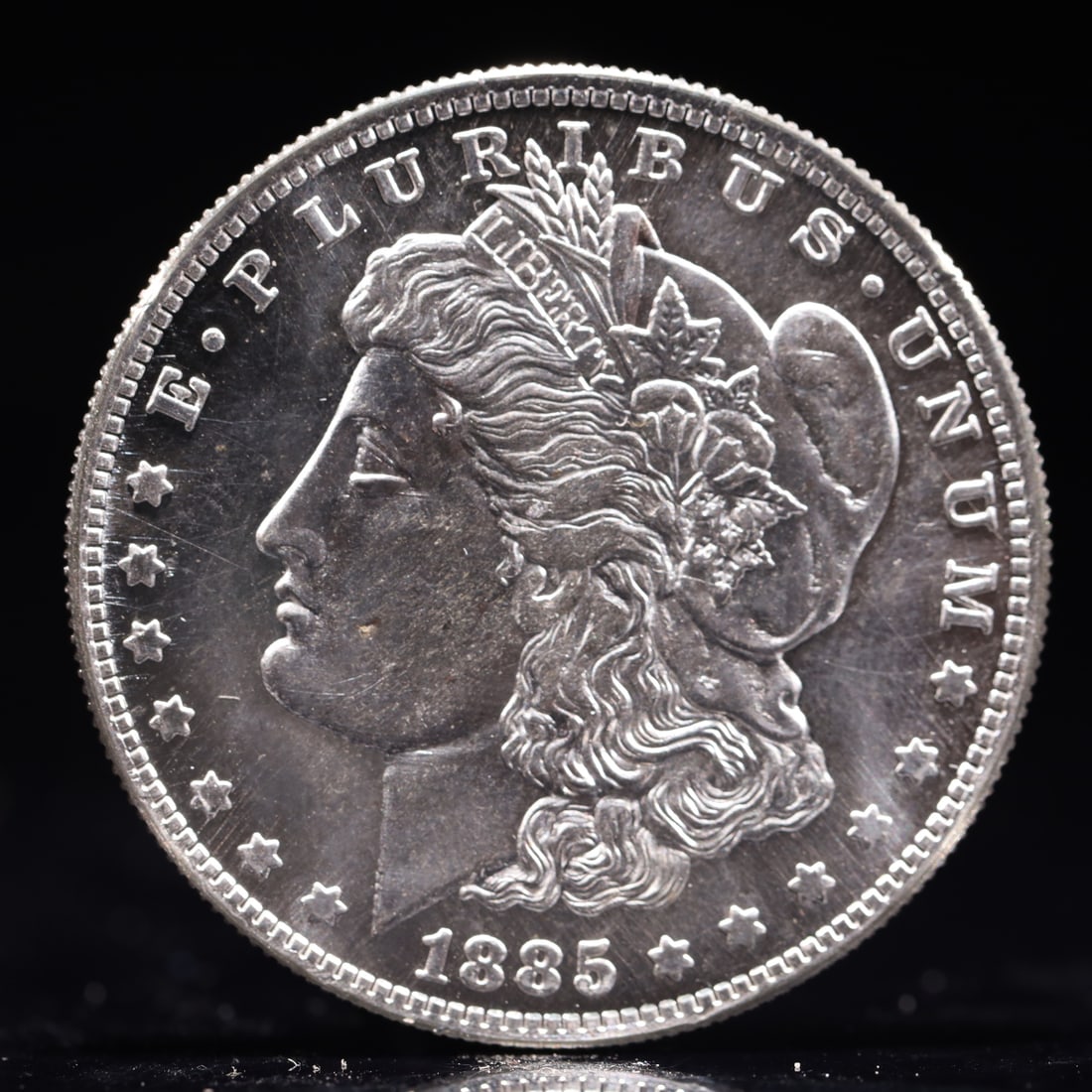 USA Morgan Dollar 1885 Coin: Obv: profile bust with date below and E PLURIBUS UNUM legend and stars around. Rev: eagle with In God we trust above within wreath with UNITED STATES OF AMERICA ONE DOLLAR legend. IN GOD WE TRUST / LI
