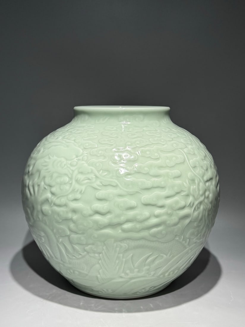 A Rare Celadon Glazed Auspicious Cloud and Dragon Pattern Jar: A Rare Celadon Glazed Auspicious Cloud and Dragon Pattern Jar,Qing Dynasty,China,Qianlong Six-character Mark,Size:11.8inx12.6in 青釉祥云龙纹罐,中国