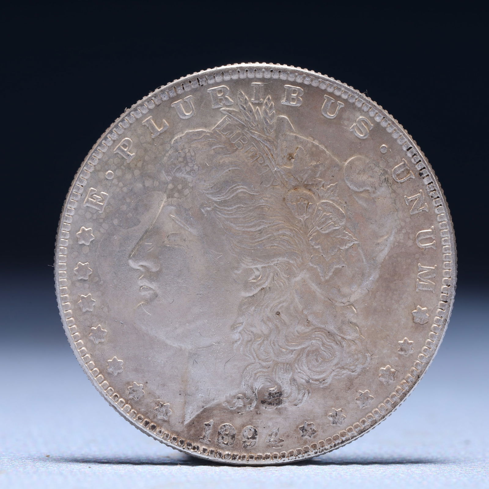 USA Morgan Dollar 1894 Coin: Obv: profile bust with date below and E PLURIBUS UNUM legend and stars around. Rev: eagle with In God we trust above within wreath with UNITED STATES OF AMERICA ONE DOLLAR legend. IN GOD WE TRUST / LI